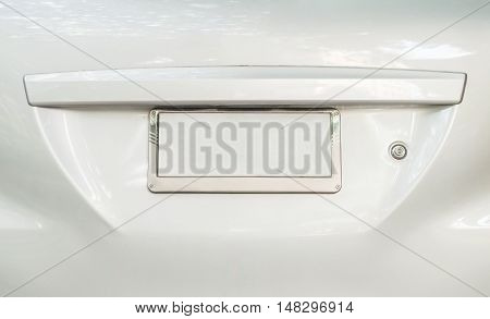 Closeup old license plate at the backside of car with space textured background