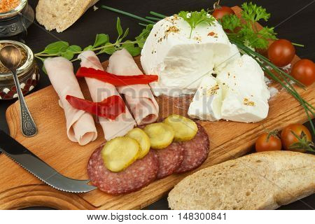 Goat cheese with vegetables and ham. Healthy diet meals for children. Goats cheese on a cutting board.