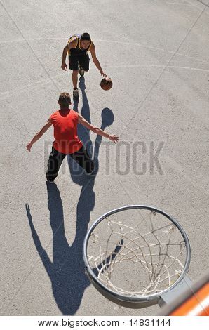 gorup de rapazes que jogar basquete ao ar livre na rua, com longas sombras e bird Ver os psicoló