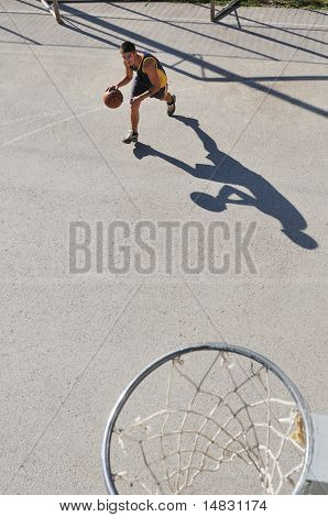 gorup de rapazes que jogar basquete ao ar livre na rua, com longas sombras e bird Ver os psicoló