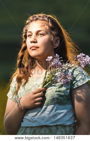 Portrait of a beautiful young teenage girl with a branch of willow in his hands