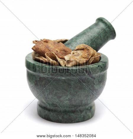 Organic Sour dried mango or Aamchur or Amchoor (Mangifera indica) on marble pestle. Isolated on white background.