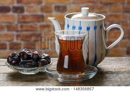 Tea with dates on wooden table. Selective focus
