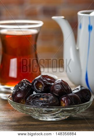 Tea with dates on wooden table. Selective focus