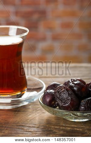 Tea with dates on wooden table. Selective focus