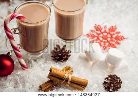 Overhead view of composite image of hot chocolates on table in fake snow