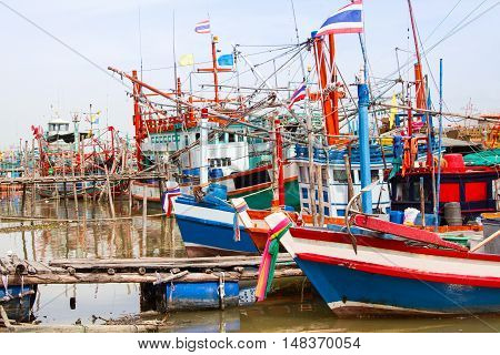 Fishing boats off work and dock in a harbour .