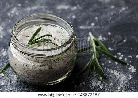 Sea salt scented herb rosemary on black stone background, vintage style.
