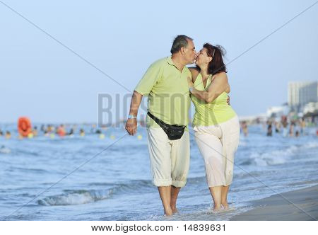 glücklich ältere Reife ältere Leute Paar haben romantische Zeit am Strand bei Sonnenuntergang