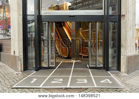 Sliding glass doors and an escalator in the Mall with number.