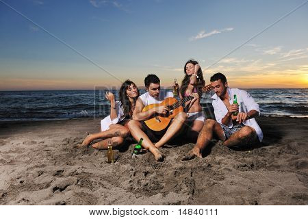 boldog fiatal meg csoport jó szórakozást, és megünnepeljük a strandon, a sunse a futás és Ugrás közben