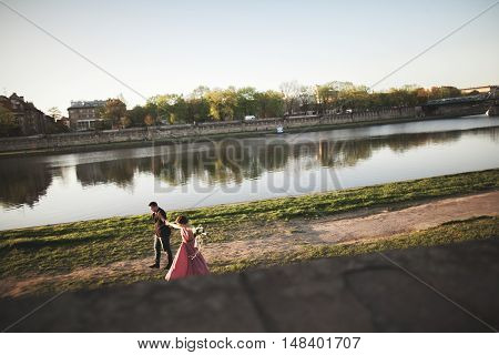 Beautiful unique couple walks into your wedding day in Krakow near river Visla.