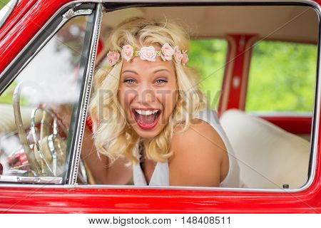 Happy woman laughing while sitting in retro car