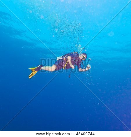 Diver with bright yellow fins and underwater camera