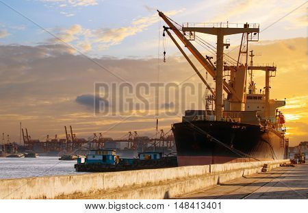 container ship loading material goods from local ship in habor port use for import export nauticla vessel and logistic transportation