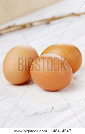 Chicken eggs on a white linen napkin.