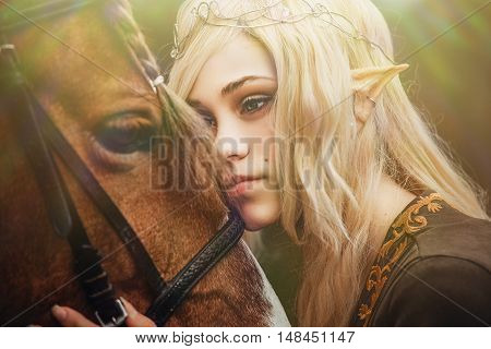 Elf woman in the forest with a horse