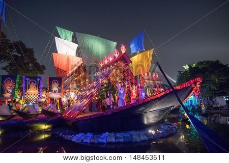 KOLKATA INDIA - OCTOBER 21 2015 : Beautiful exterior of decorated Durga Puja pandal at night Howrah West Bengal India. Shot under colored lights. Durga Puja is biggest religious festival of Hinduism.