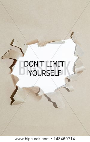 DON'T LIMIT YOURSELF written under torn paper