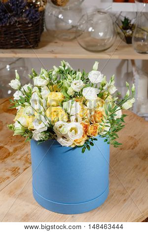 Rich bunch eustoma white and yellow roses of composition in hatbox. A fresh bouquet flowers different colors mix.