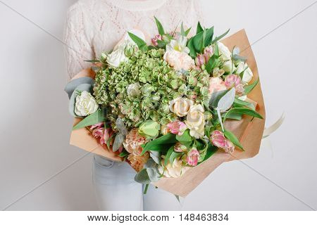 rich bouquet with hydrangea in woman hand . colorful roses and various color mix flowers.