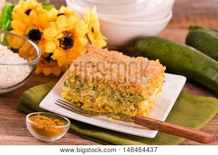 Rice timbale with zucchini on wooden table.