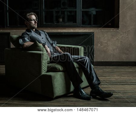 Businessman sitting on an armchair. Fahion man.