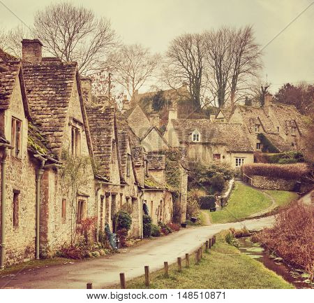 Old street with traditional cottages in Bibury, England, UK. Toned image.