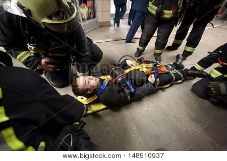 RUSSIA, MOSCOW - FEB 26, 2015: Suffer is laying on the hand-barrow with oxygen mask at Preobrazhenskaya ploshchad subway.