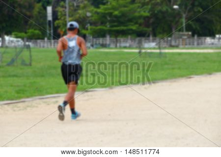 Blur blurred abstract young man jogging in the park rear view