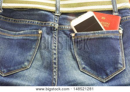 Passort and mobile phone in the pocket of blue jeans a man goes on a big journey