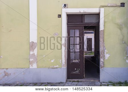 Facade of an old house with door from the street opened to a yard with next door. House number five. Mosonmagyarovar Hungary.