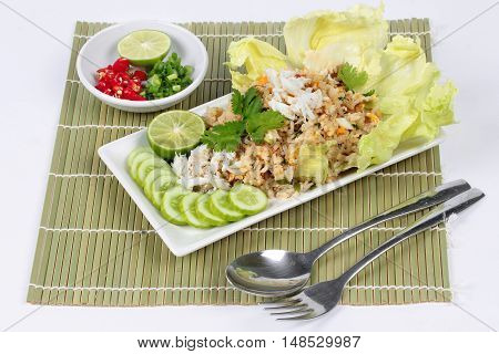 Fried rice with crab topped streamed crab,halve green lemon,sliced cucumber,lettuce and coriander  served  spicy  sour filling side dish. Side view.