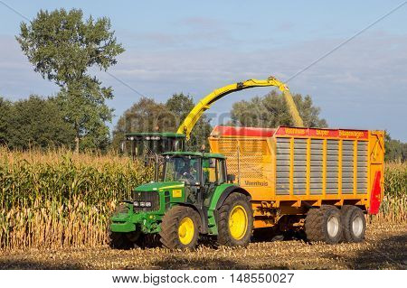 RUURLO THE NETHERLANDS - SEP 19 2016: John Deere 6930 tractor and John Deere 7480i Forage Harvester at work.