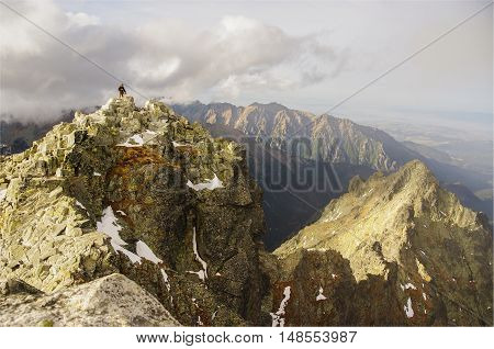 Beautiful mountain landscape. Single man stands on top of a mountain. Tatry. Rysy