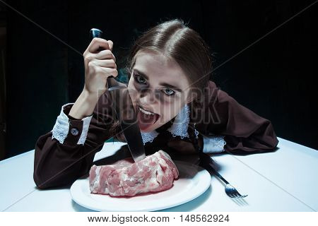Portrait of a young girl with knife and and a piece of raw meat on a plate. Girl in school uniform as killer. The image in the style of Halloween and Addams family