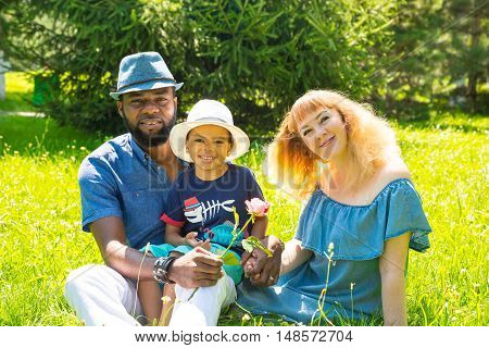 African American happy family: black father mom and baby boy on nature. Use it for a child parenting or love concept