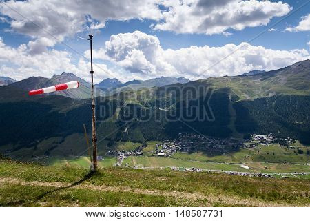 Red And White Striped Windsock Dramatic Clouds Mountains In Background