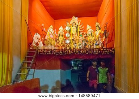 KOLKATA INDIA - OCTOBER 18 2015 : Night image of decorated Durga Puja pandal on upper portion of a narrow street. Editorial image shot at colored light at Kolkata West Bengal India.