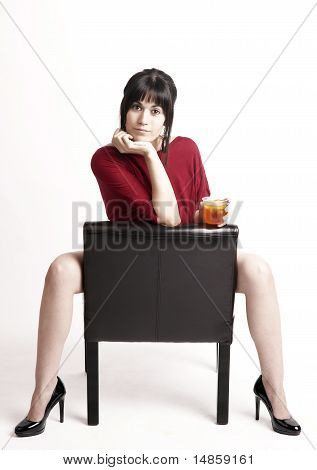 Brunette Female Straddles Chair Seemingly Asking you to Have a Drink