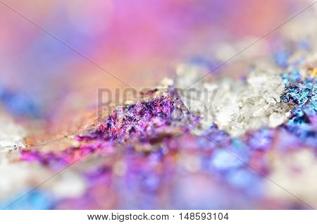 Bornite ore crystallizes mineral its blurred natural background. Macro. Focus on the central. Very shallow depth of field