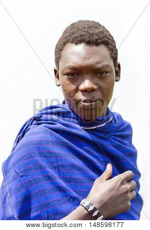 AFRICA, KENYA, MAY, 08, 2016 - Maasai Mara tribe men in a blue cape at Maasai Mara National Park, Kenya, Africa.  The Maasai (sometimes spelled Masai) are a Nilotic ethnic group of semi-nomadic people inhabiting southern Kenya and northern Tanzania.