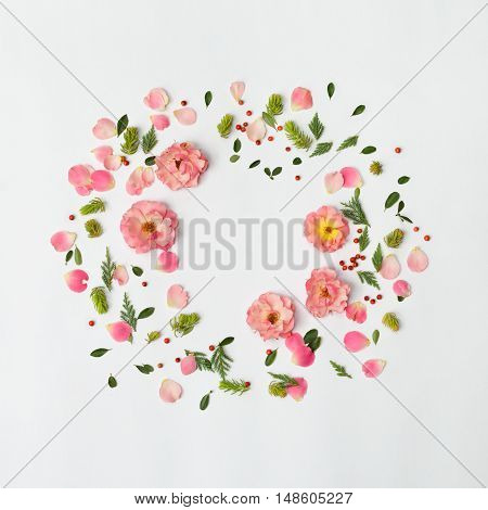 Flat nature floral round frame on white background top view. Ornament with rose flowers petals succulent plants red berries and green leaves.