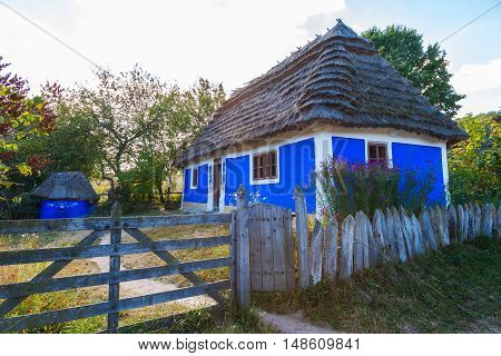 Traditional ukrainian cottage with thatched roof in Pirogovo village Kiev region Ukraine.