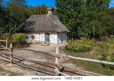 Retro ukrainian cottage with thatched roof and garden in Pirogovo village Kiev region Ukraine.