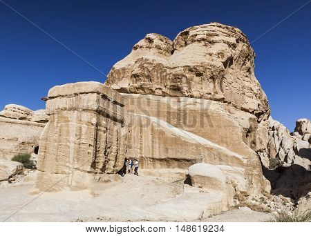 PETRA JORDAN - OCTOBER 29 2014: Unidentified tourists near one of the Djinn Blocks - the monuments that served as tombs and memorials to dead.