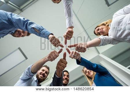 Businesspeople showing thumbs up in an offiice.