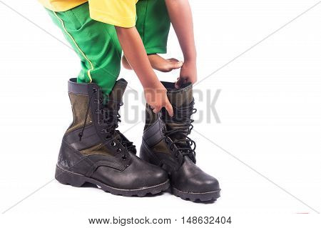 little boy try wearing big shoe on white background