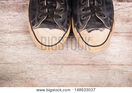old canvas shoes on brown wooden background