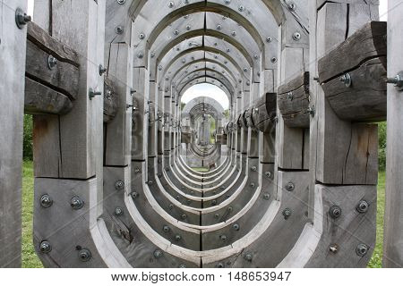wooden tunnel through which one can see nature